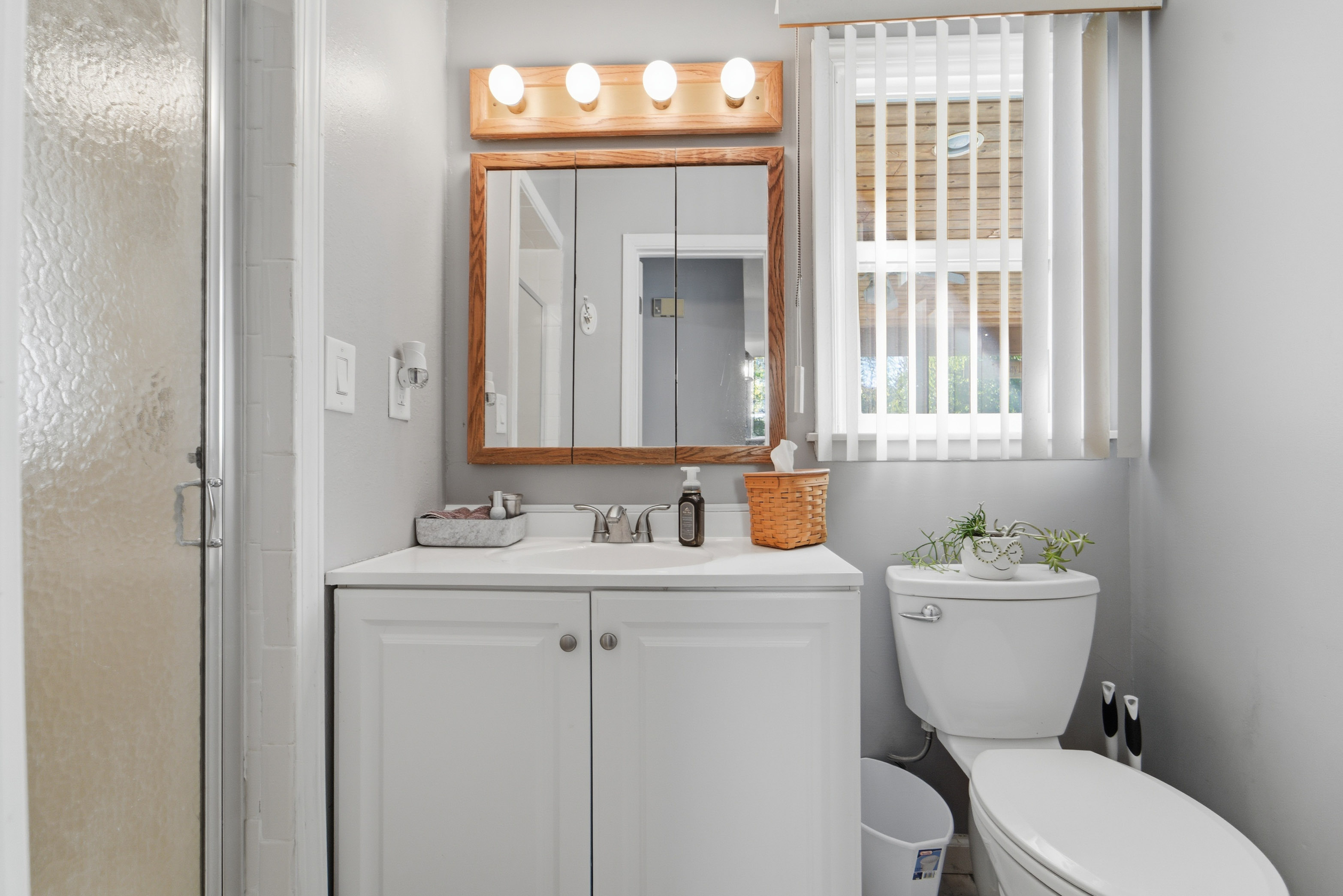 The basement bathroom is full of natural light and a newer tile shower.