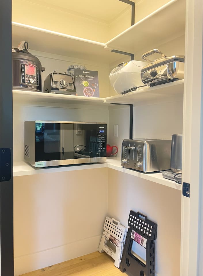 Food pantry with all the kitchen appliances, and step stools.