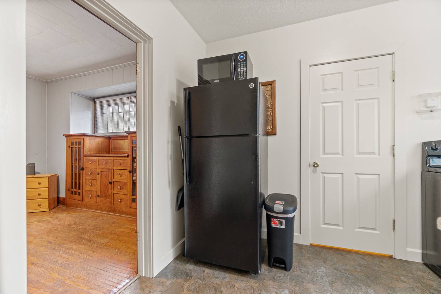 Full kitchen featuring a refrigerator, trash bin, and a convenient divider leading to the adjacent bedroom—creating a functional, well-organized space with easy access and a seamless flow between living and kitchen areas