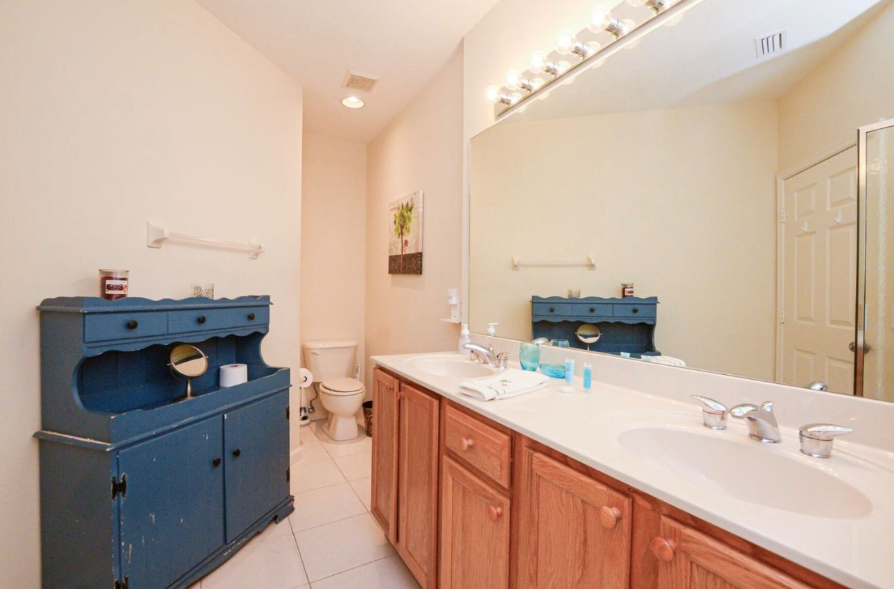 Spacious bathroom with double-sink vanity, tile flooring, and plenty of counter and storage space.