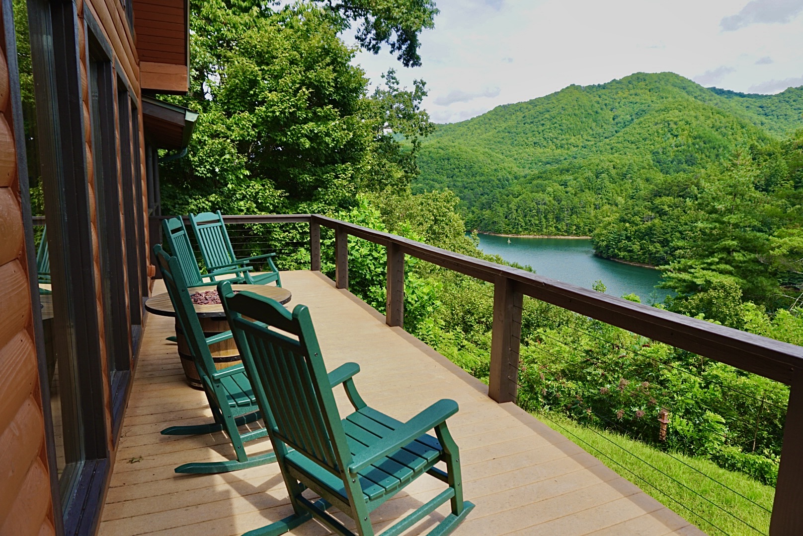 Deck with a View: Relax in rocking chairs overlooking lush mountains and serene waters!