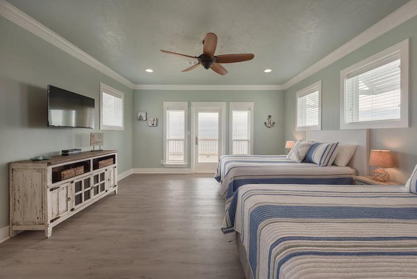 Breezy Point Bedroom 4: Offers two queen beds plus a twin trundle, ideal for larger families or groups, plus private deck access to enjoy the ocean and sunsets.