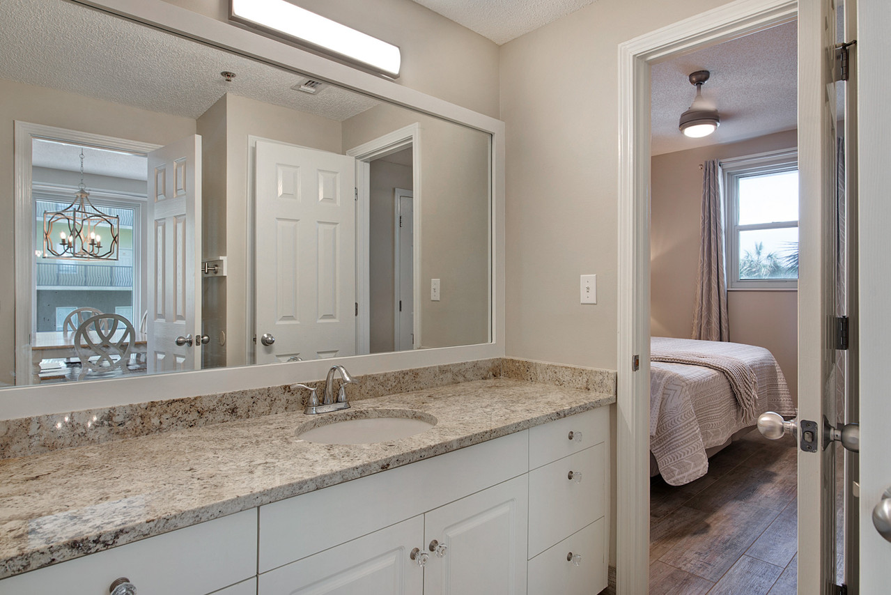 Guest bathroom with twin vanities and walk-shower accessible from living room