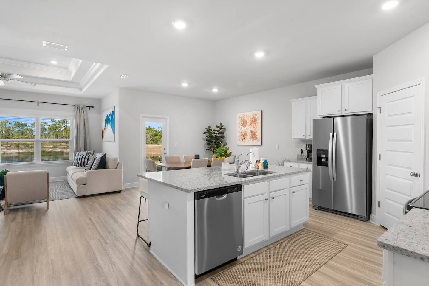 Spacious kitchen with 4-stool counter, top appliances, and seamless flow into dining and living areas.