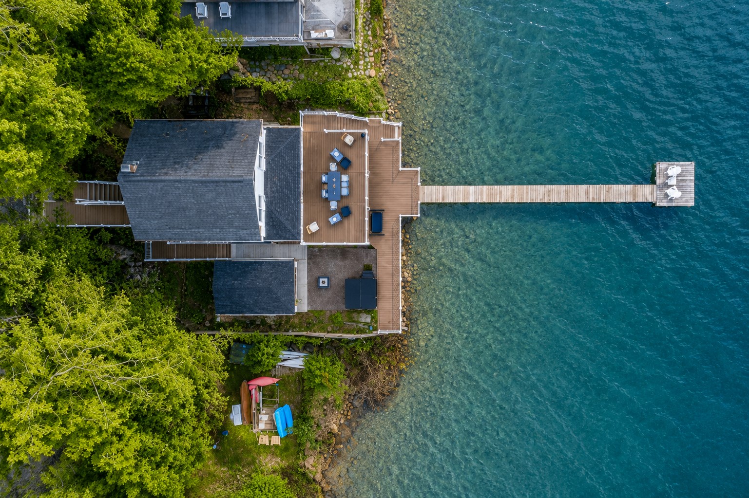 Aerial shot showcasing expansive lakefront entertaining space, hot tub, and private dock for the ultimate getaway 🎯🌊🍹