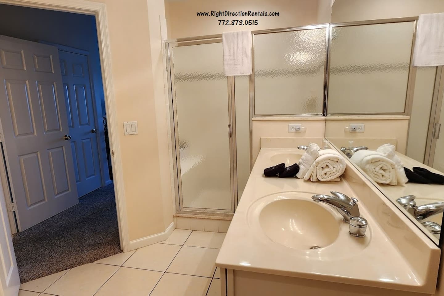 Bright bathroom with large mirror, walk-in shower, and convenient vanity space.