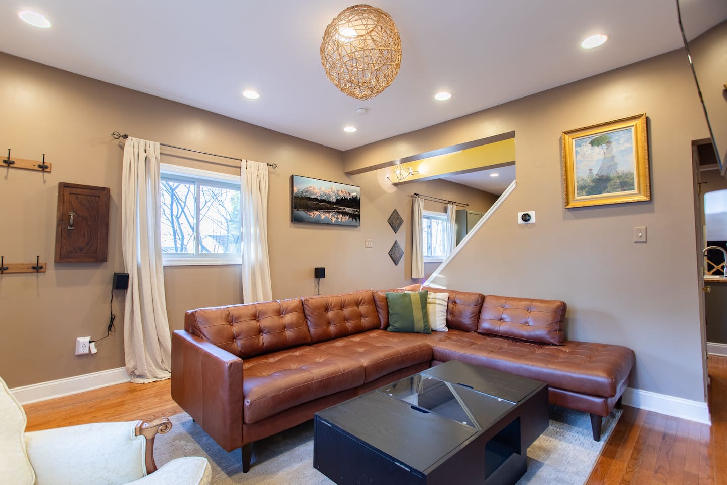 Bright and inviting living space featuring a modern leather sectional, soft ambient lighting, and curated artwork—perfect for relaxing after a day of exploring