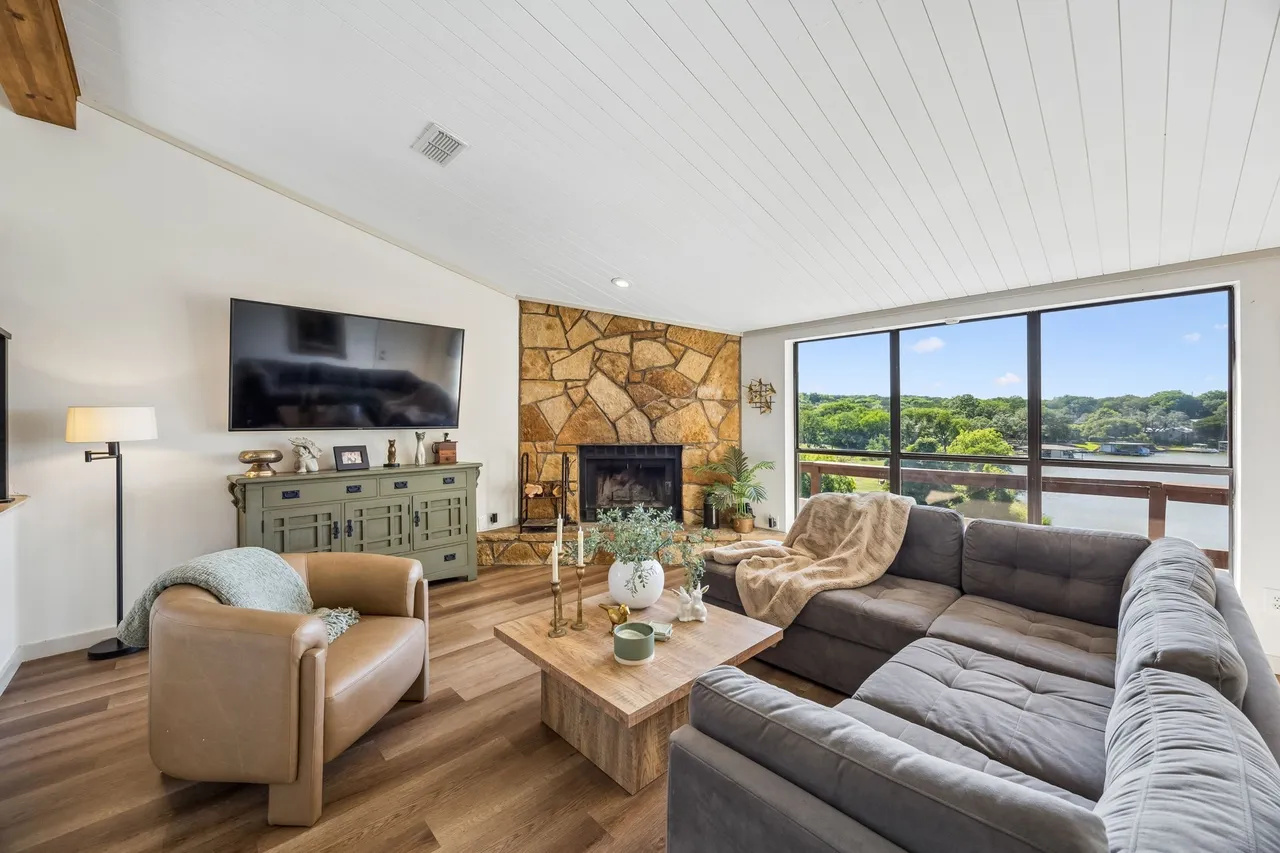 Comfortable living room with fireplace, television, and lake views.