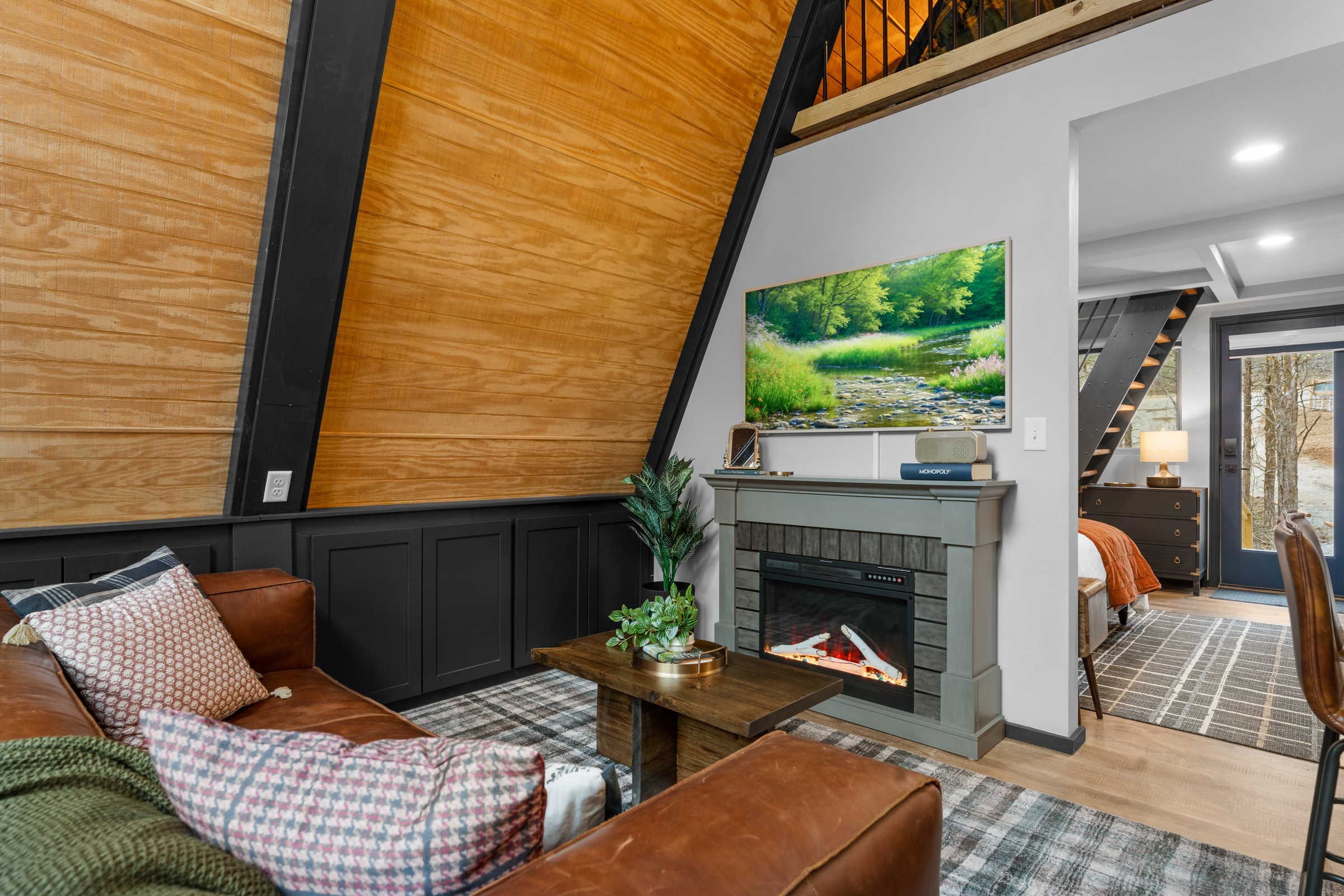 Living room with leather sofa and electric fireplace. Flip it on, sink in, and the queen bed is just steps away.
