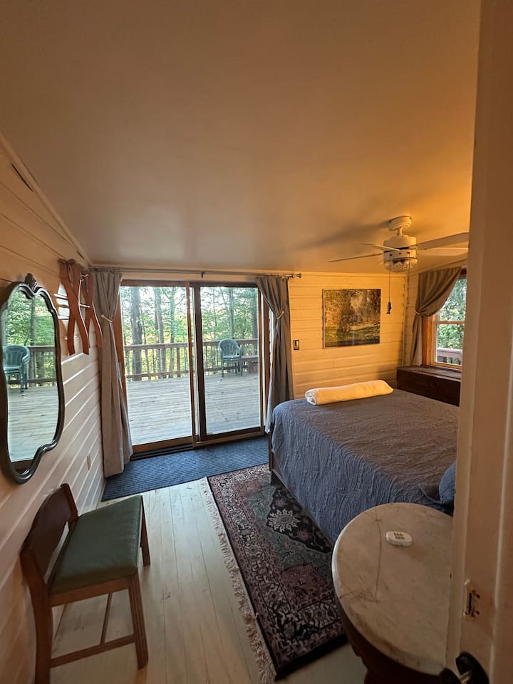 Rest easy in the main double  bedroom, complete with soft linens, blackout curtains, and charming cabin views. Quiet, private, and ideal for a good night’s sleep after a day outdoors.