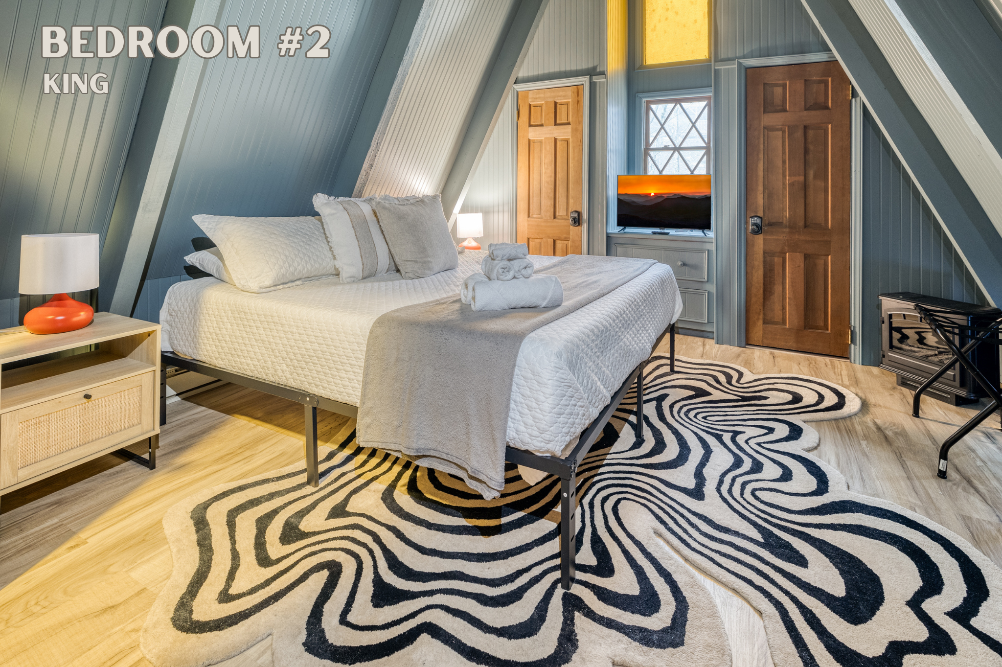 Nestled upstairs, Bedroom #2 boasts a king-sized bed. Relax and unwind with the convenience of a TV for your entertainment, making it an ideal retreat after a day of exploring.