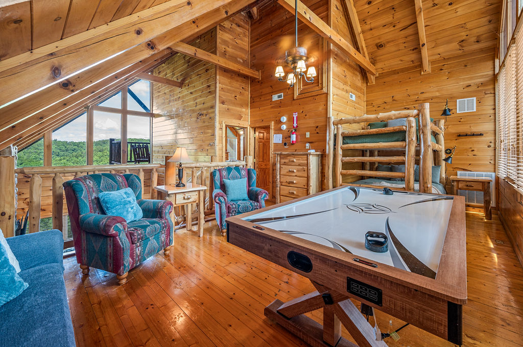 Cozy loft space with seating, a bunk bed, and an air hockey table.