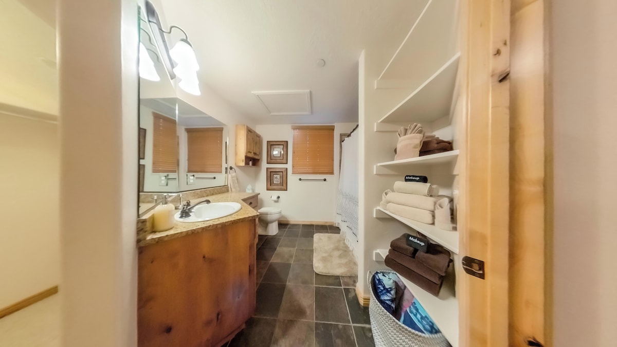 The primary bathroom features plenty of counterspace, ample storage, a hair dryer, and expansive mirrors.