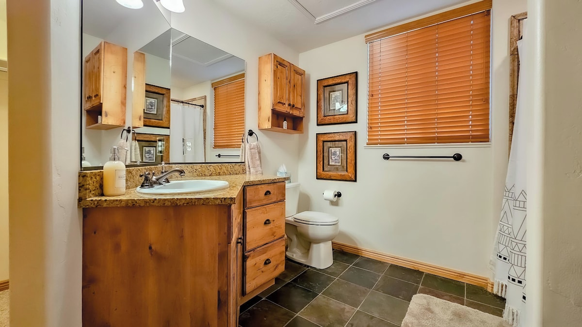 The primary bathroom features plenty of counterspace, ample storage, a hair dryer, and expansive mirrors.