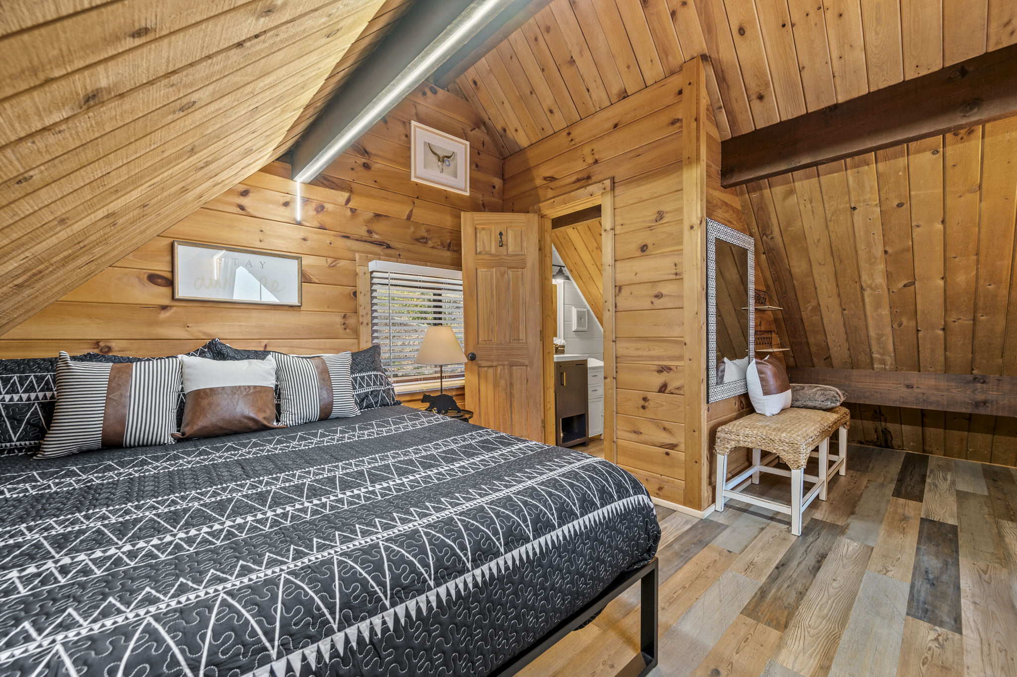 The primary loft suite is private, but does not have doors. It features a king bed, new ROKU TV and private 1/2 bath.  