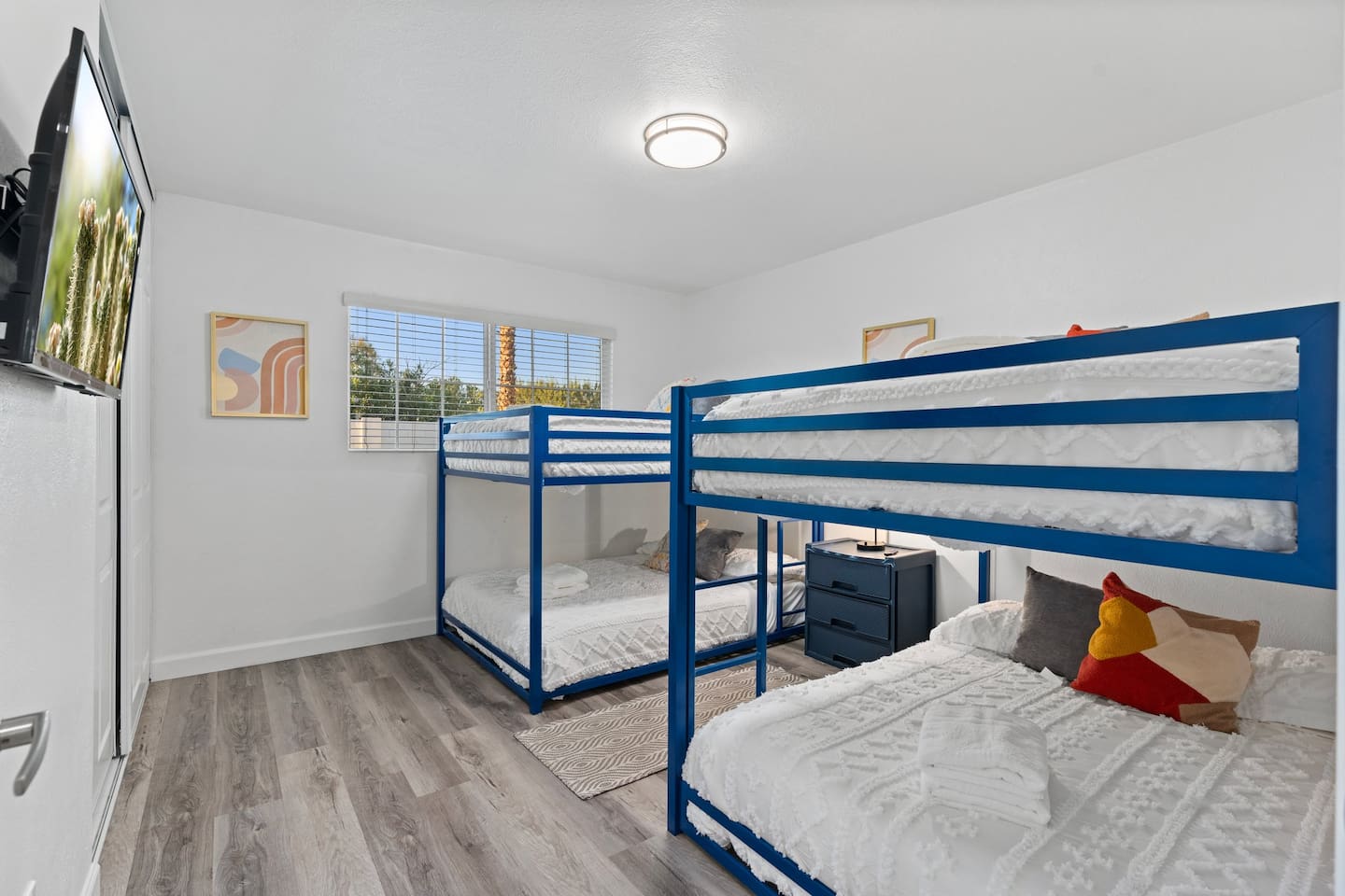 This spacious bedroom features two full-over-full bunk beds with colorful pillows and cozy bedding, perfect for kids or groups.