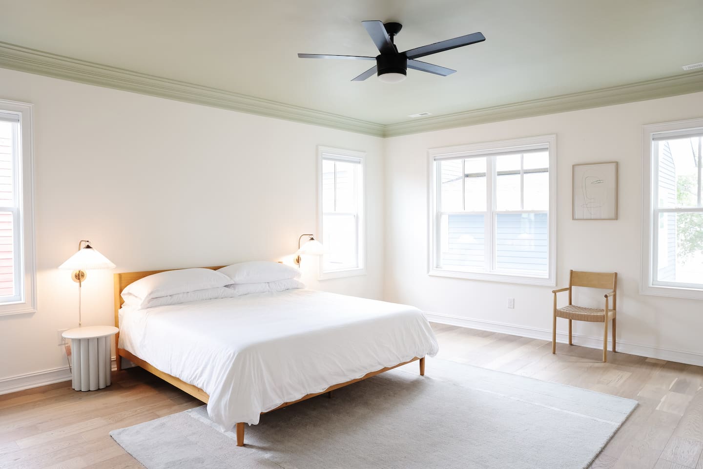 The spacious primary bedroom is a serene place to relax and recharge. The primary features a king sized bed, accents from CB2, walk-in closet, 50" Smart TV, and a full bath with a soaking tub and standup shower. 