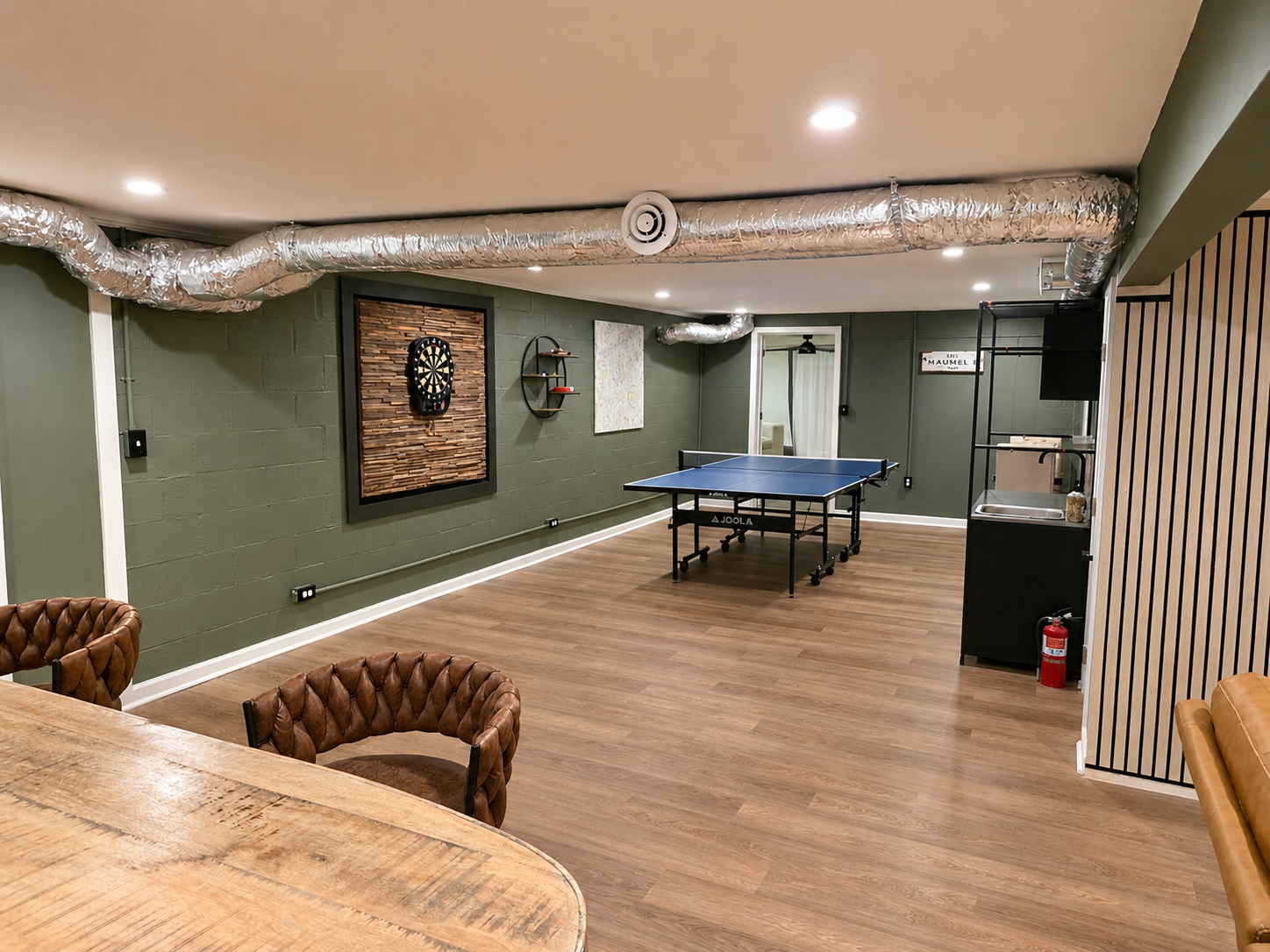 Spacious basement game room with ping pong, darts, bar seating and plenty of room to hang out.