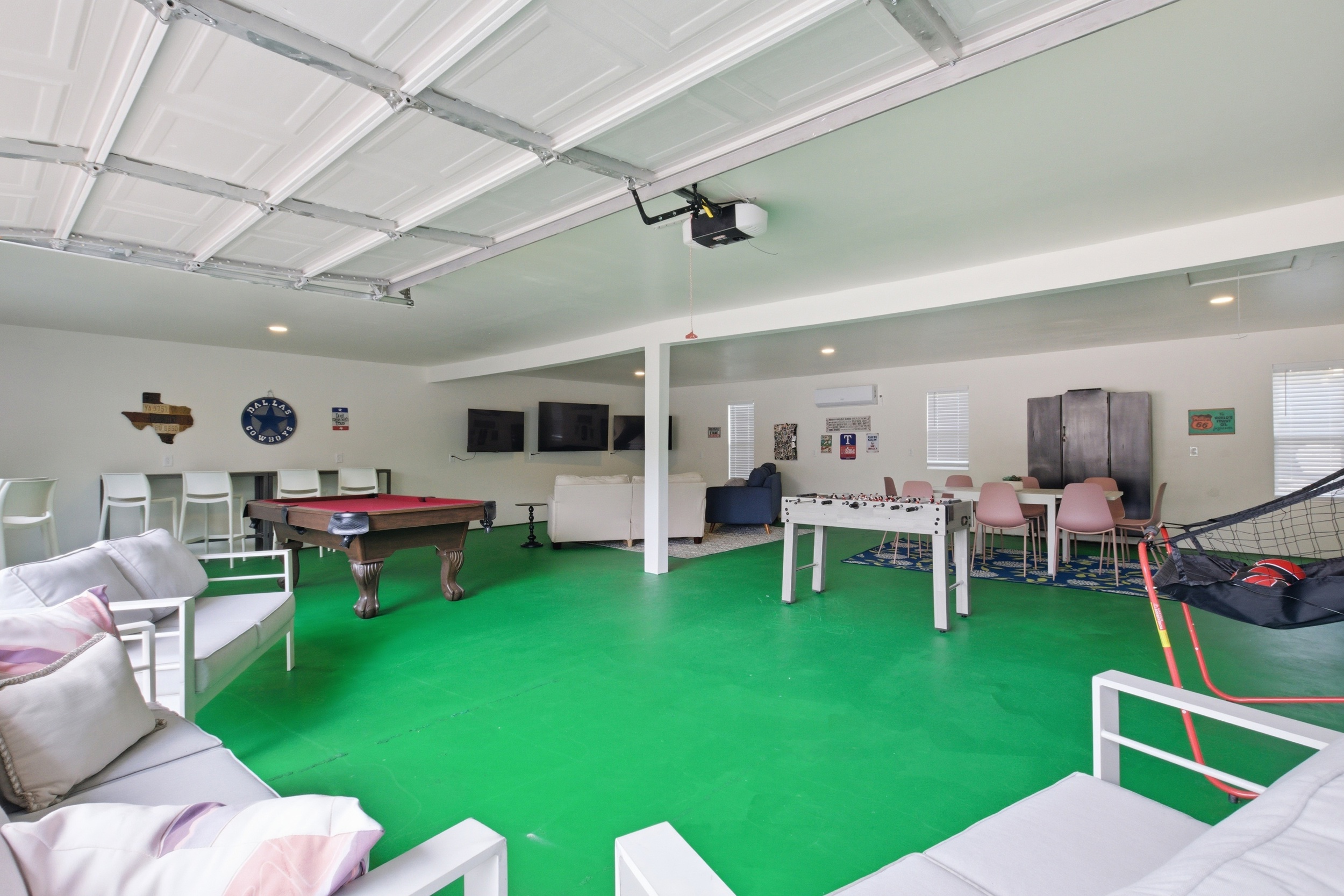 Wide-angle Game Room view showing full 1,000 sq ft layout. Pool Table, Smart TVs, Foosball, and Arcade Games — everything included for group stays near Globe Life Field.