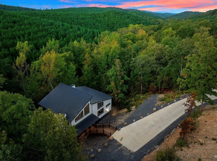Aerial view showcasing the home surrounded by lush forest privacy