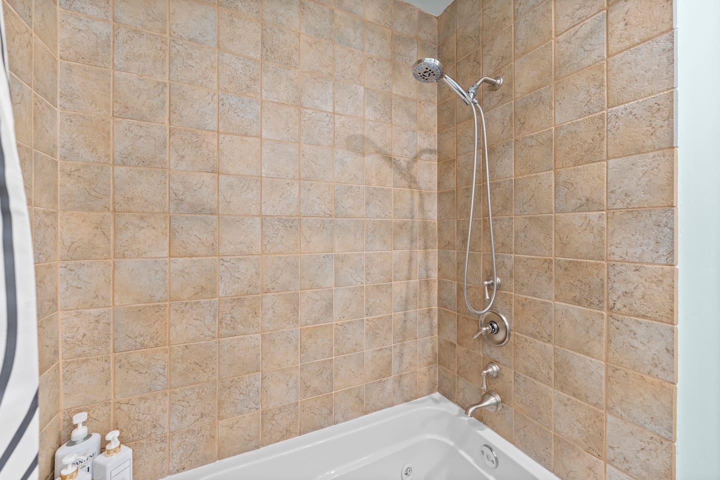 Refresh in a clean, tiled shower with detachable showerhead and deep soaking tub — perfect for relaxing after a day out.