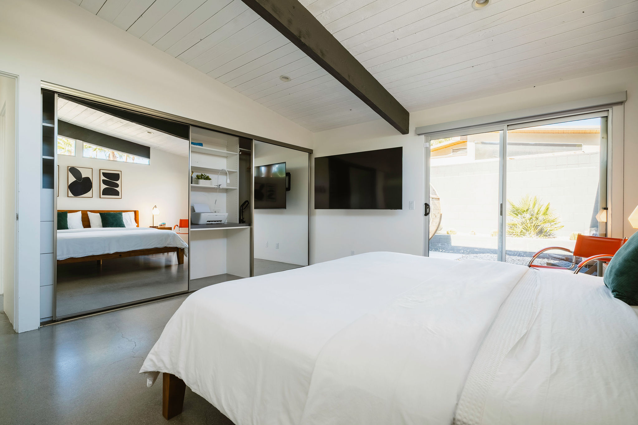 Front bedroom with Smart TV, patio, and working desk with printer nestled in the closet