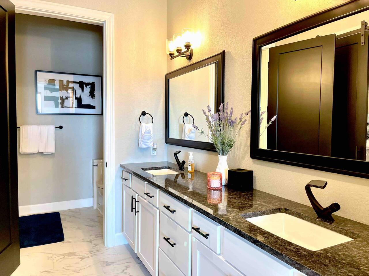 Master bathroom en-suite with double sinks, lots of cabinets, and separate toilet and shower area. 