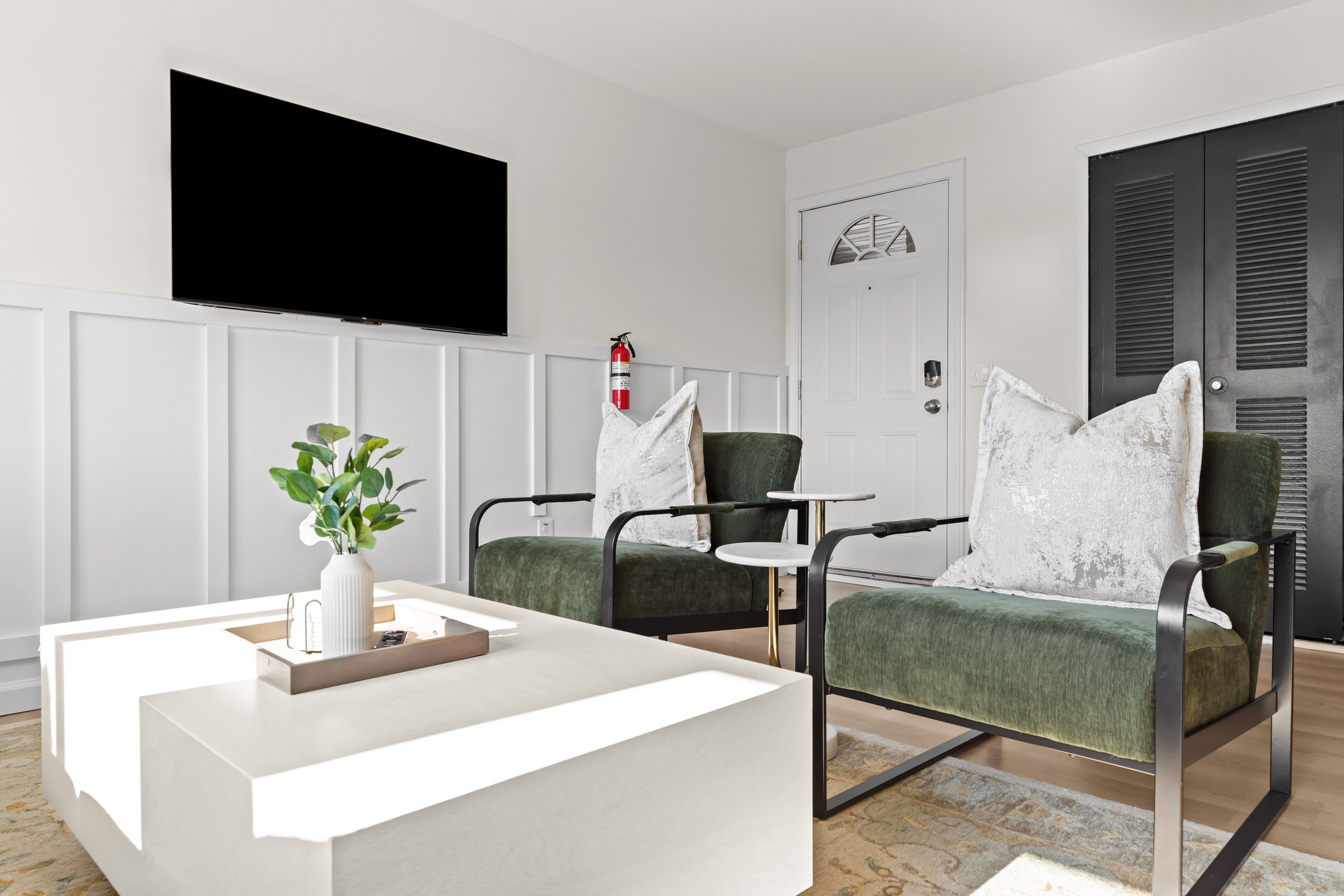 Bright and modern living space featuring a cozy green velvet sofa and minimalist décor.