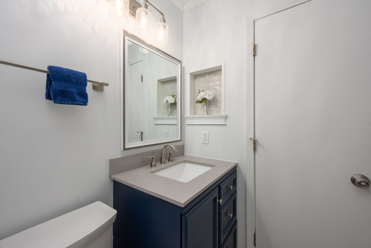 Bathroom with new tile shower, vanity, fixtures, and additional storage space.