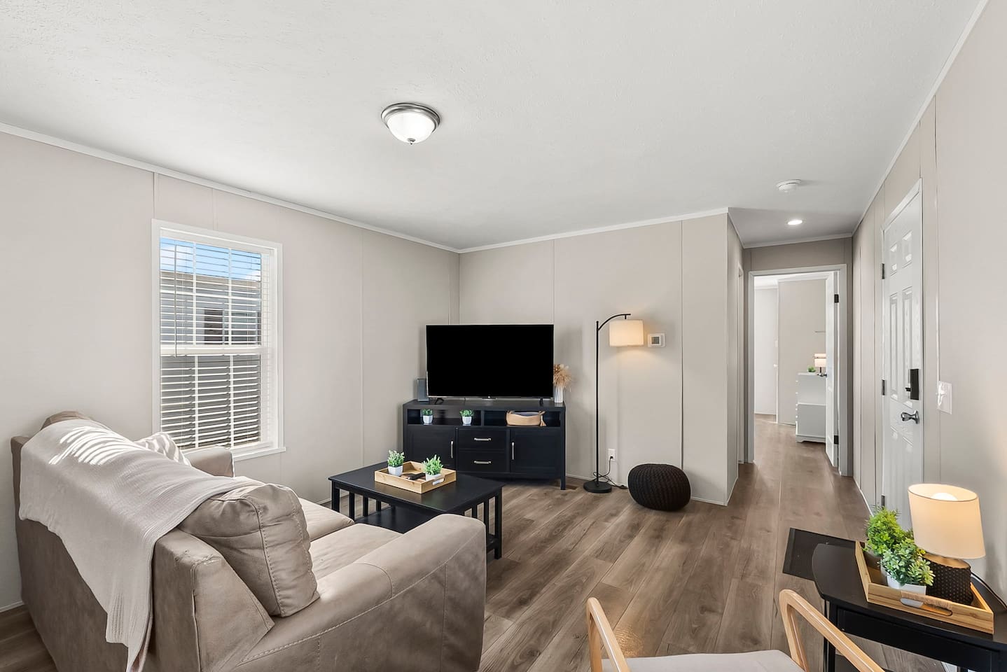 Spacious living area with natural light, plush sofa, and TV—ideal for unwinding after a long day in Warren.