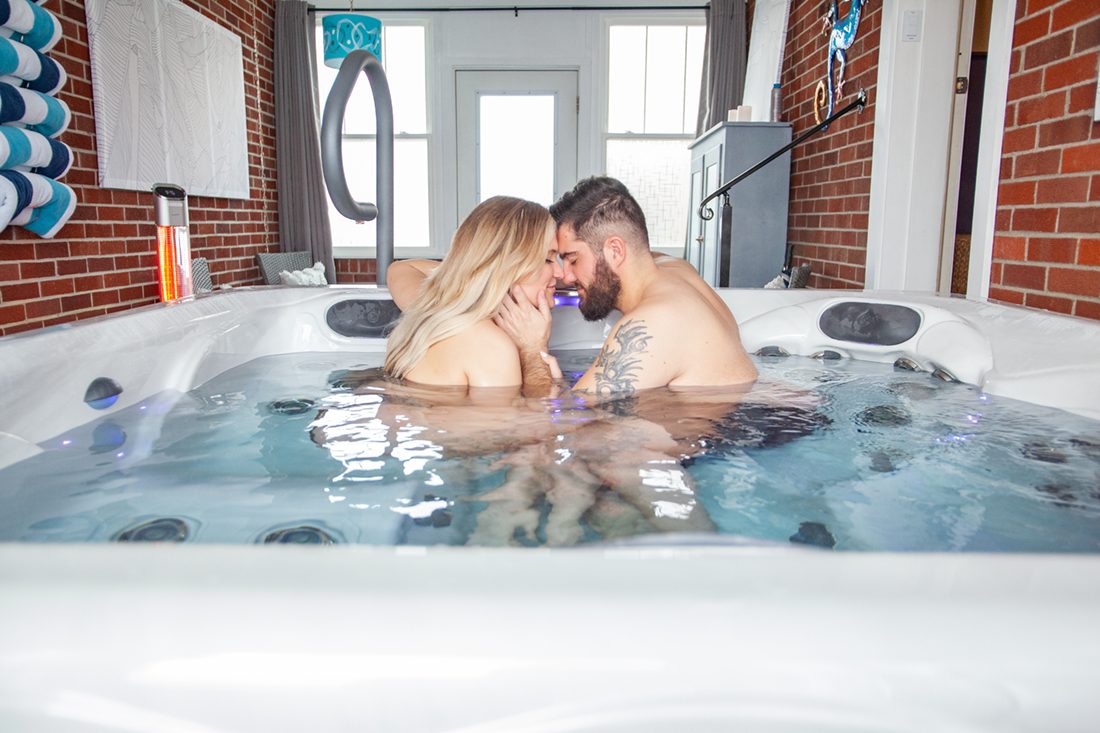 Indoor/outdoor breezeway hot tub—custom garage door opens to the private backyard.