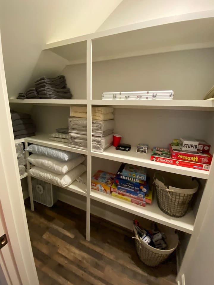 Closet in kid room with games and extra towels.