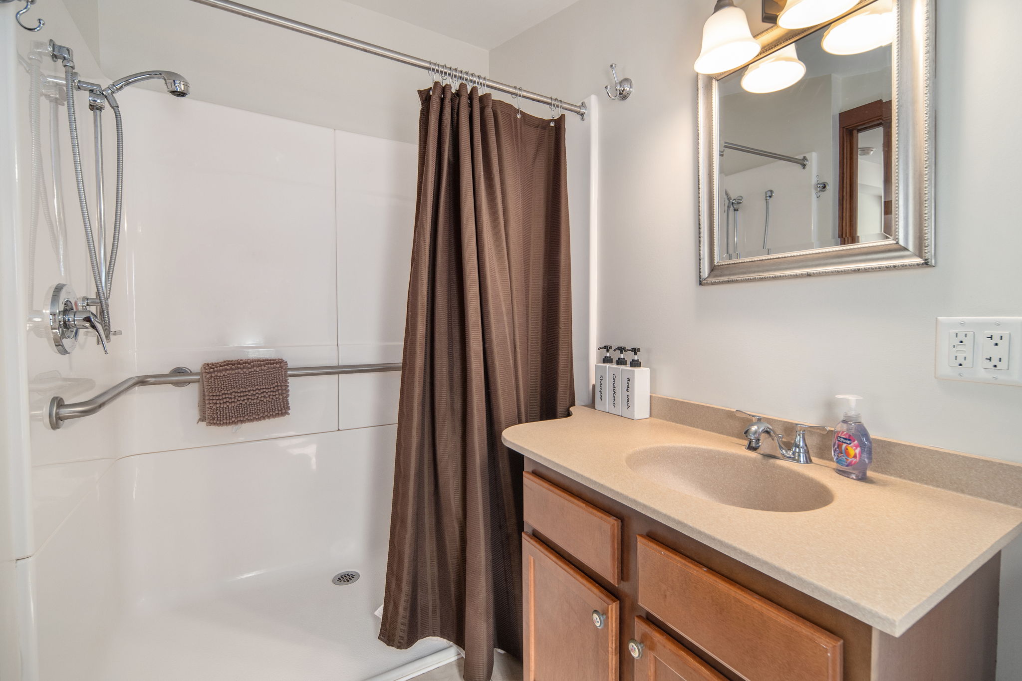 A full bathroom with a shower and vanity.