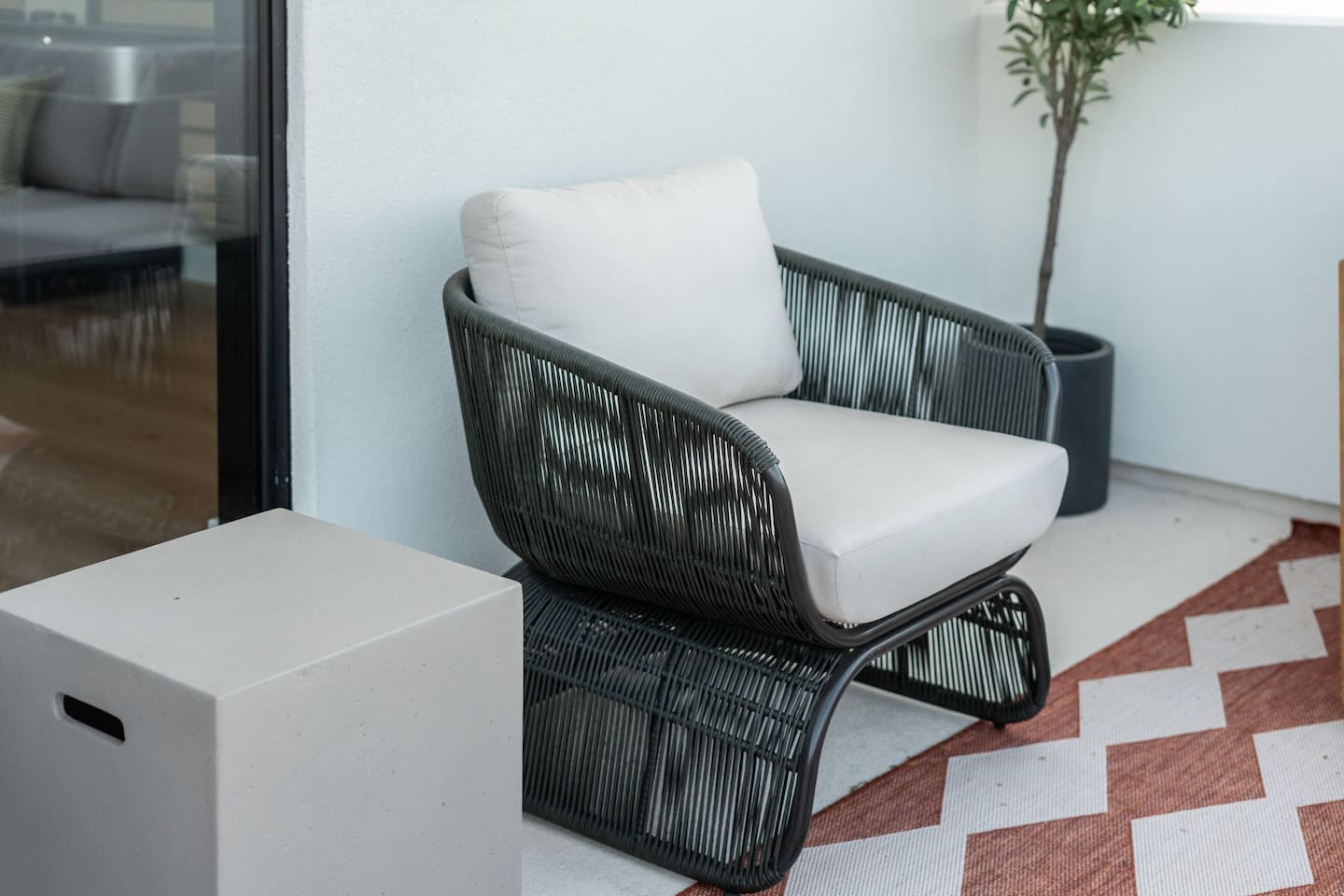 Unwind in style with this modern woven lounge chair, complete with a plush cushion for ultimate comfort.