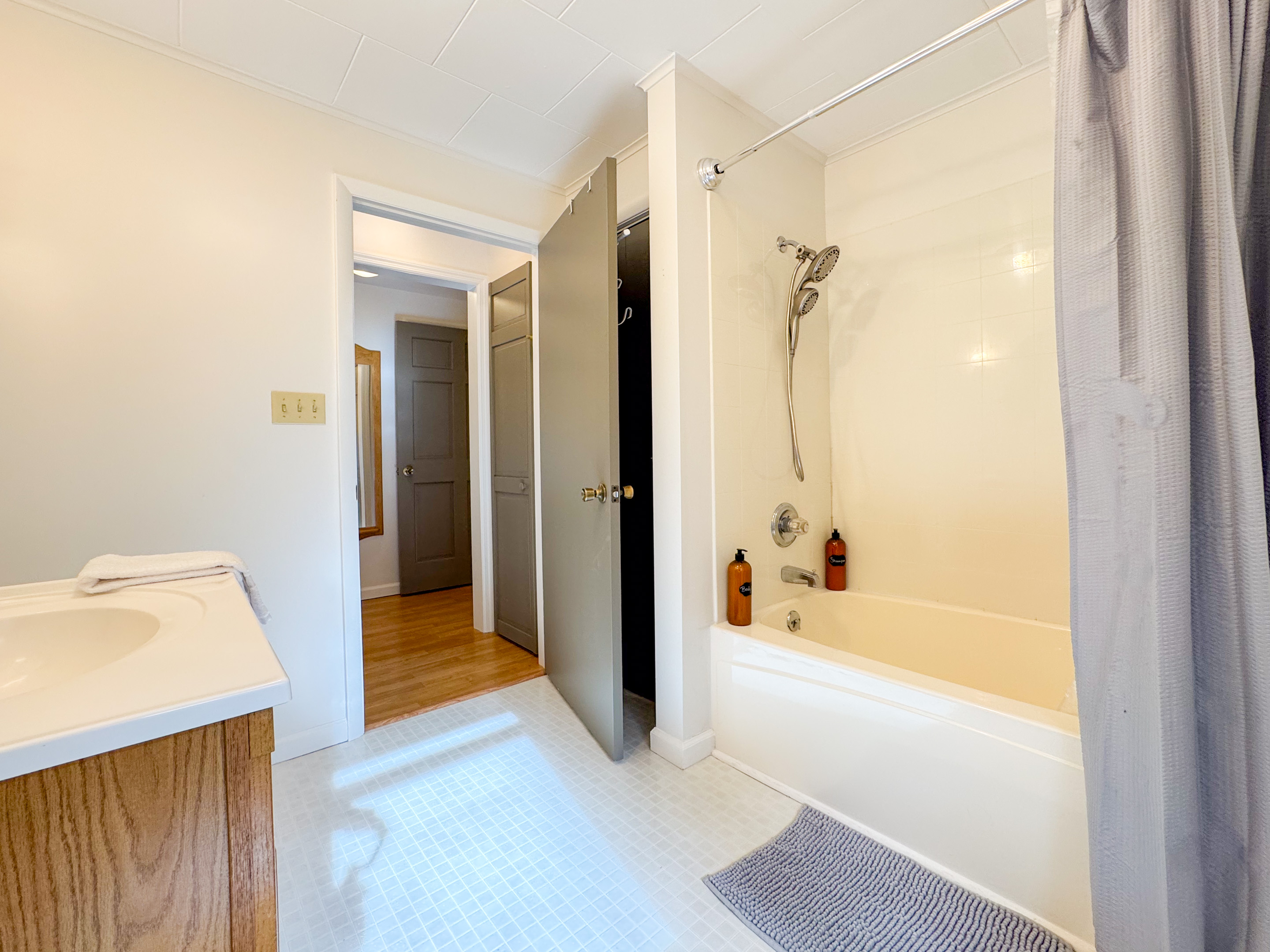 The guest bathroom in the center of the house features a tub/shower combo, toilet, vanity, and our supplied paya organics body wash and shower gel.