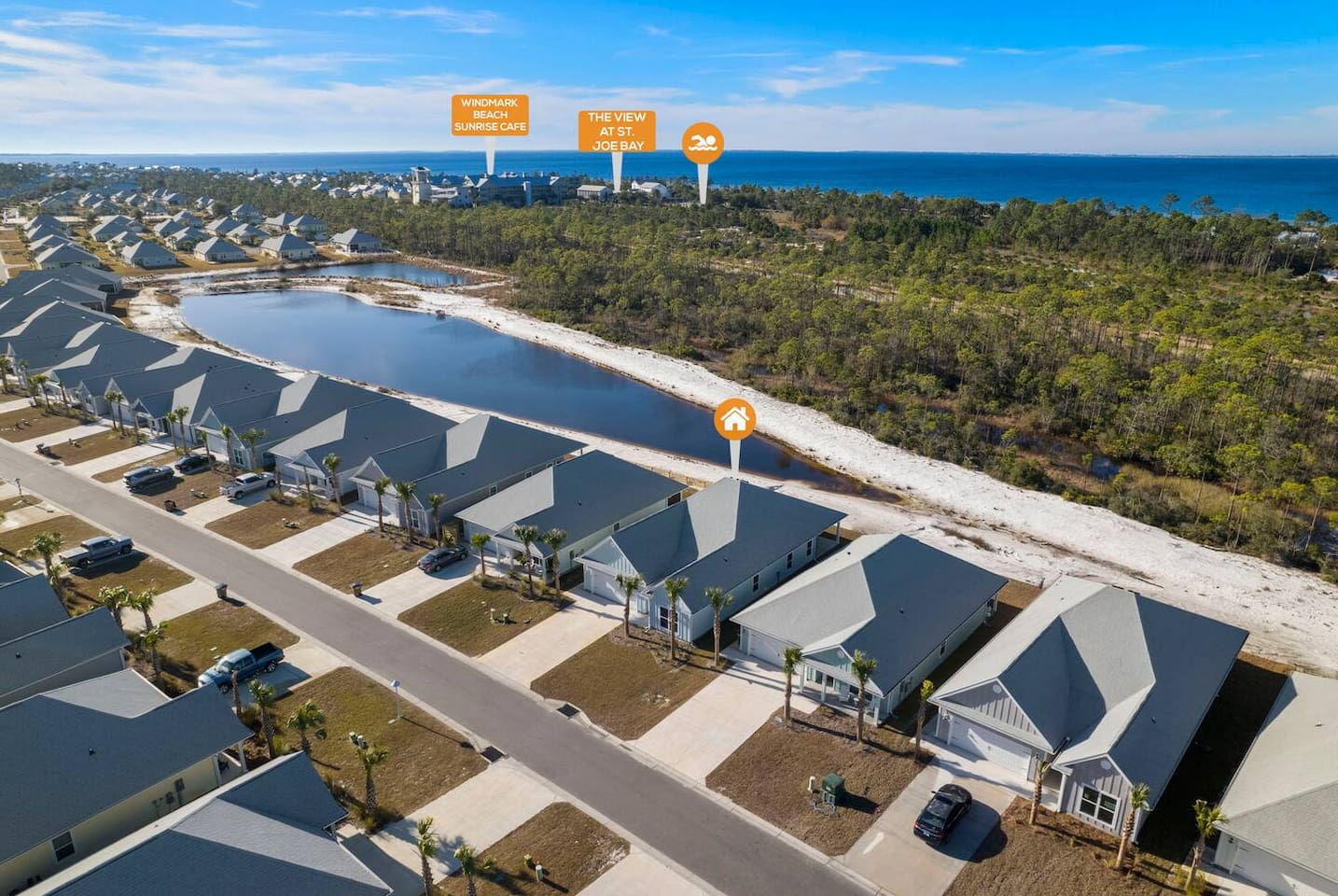 Aerial view of a peaceful coastal community surrounded by nature and water views.