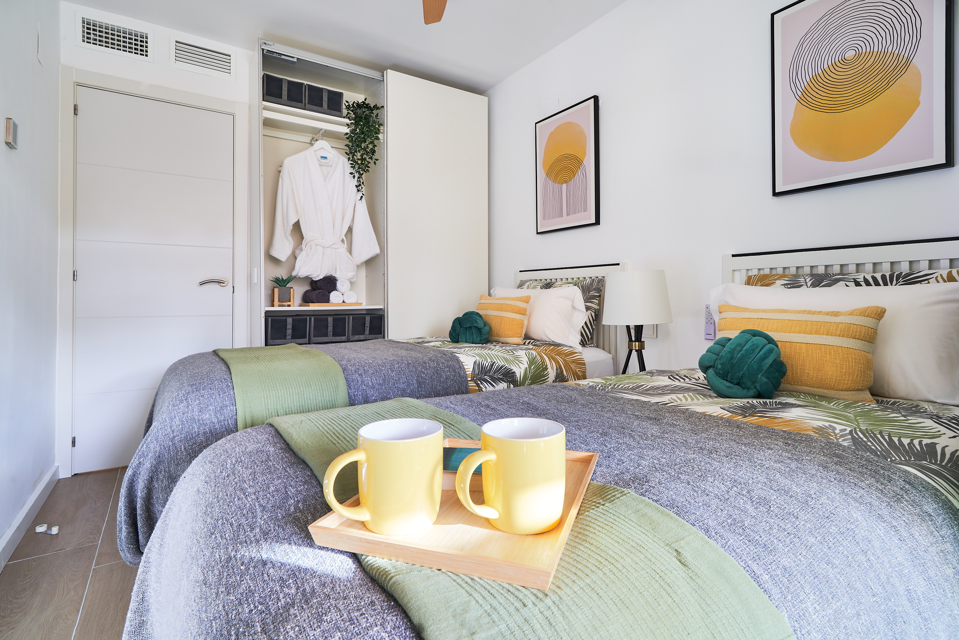 Bright and calming twin bedroom with tropical tones, soft linens, and direct access to the terrace - perfect for relaxed mornings and restful nights.
