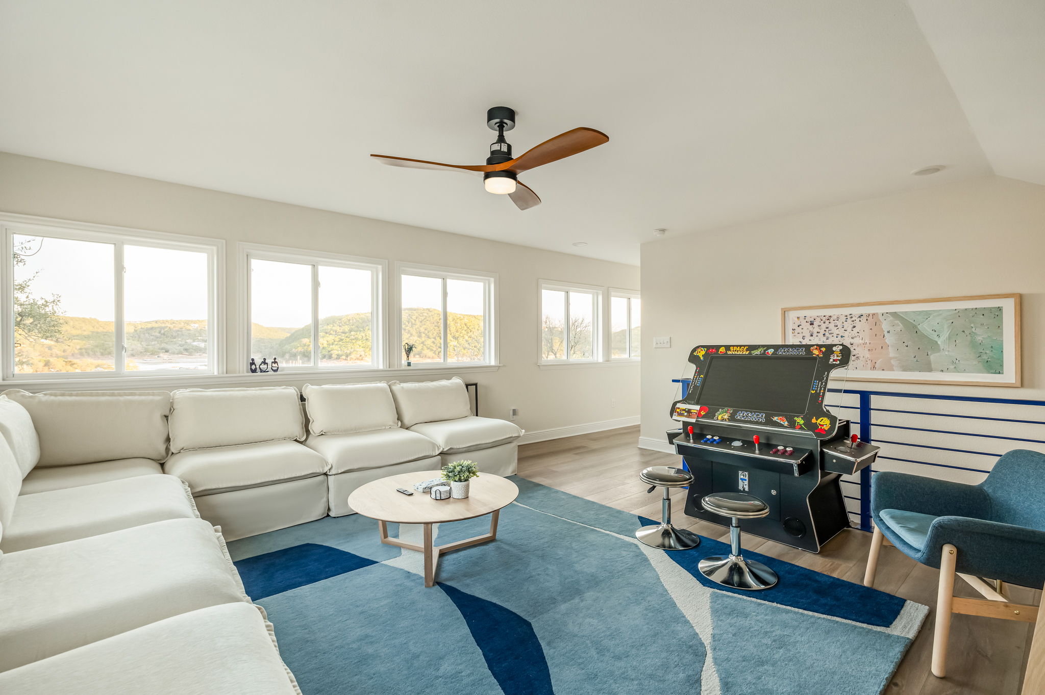 Spacious upstairs lounge with wraparound sectional and arcade games — perfect for movie nights and hangouts.