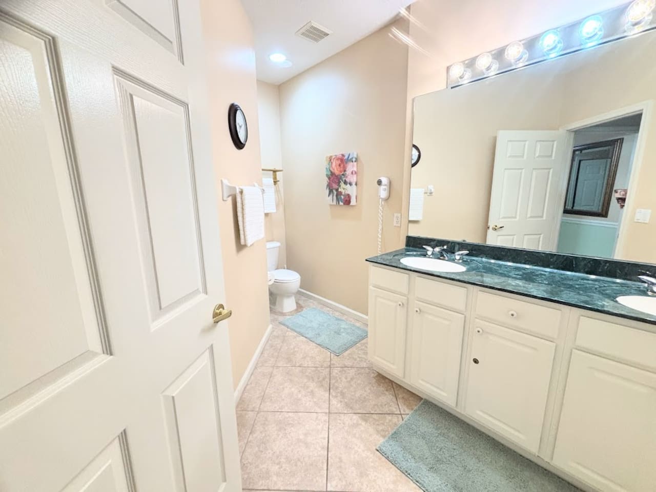 Spacious bathroom featuring a large vanity, tile flooring, and clean neutral finishes.