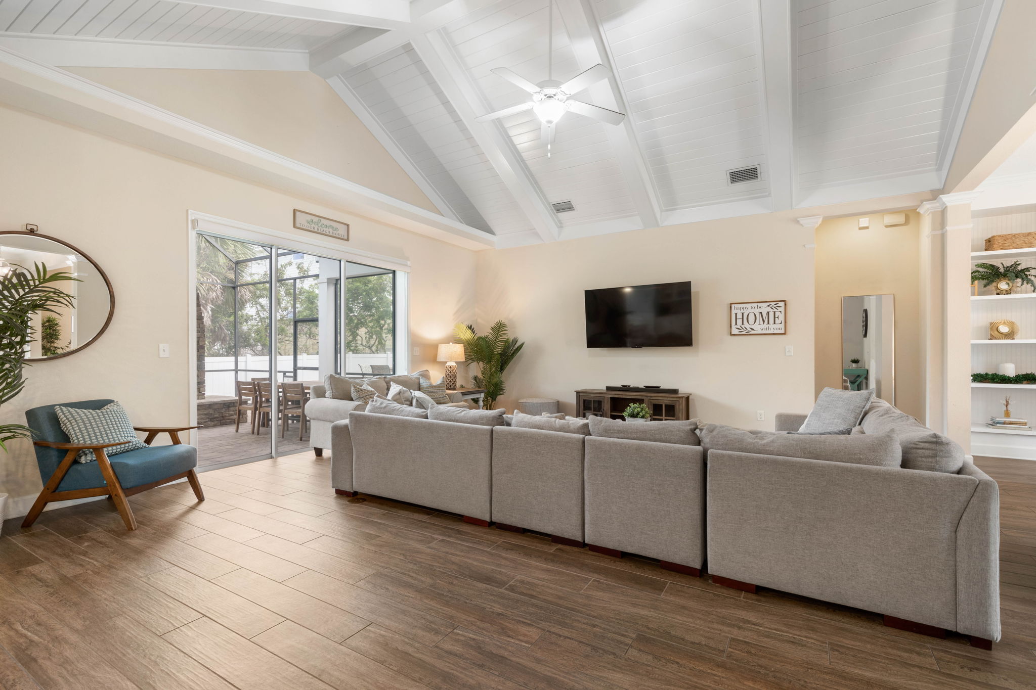 Throw open the sliders, drift from the lanai to the oversized sectional, and settle in beneath the soaring ceiling—movie nights, post-beach laughter, and slow coastal evenings all feel better in a room made for gathering.