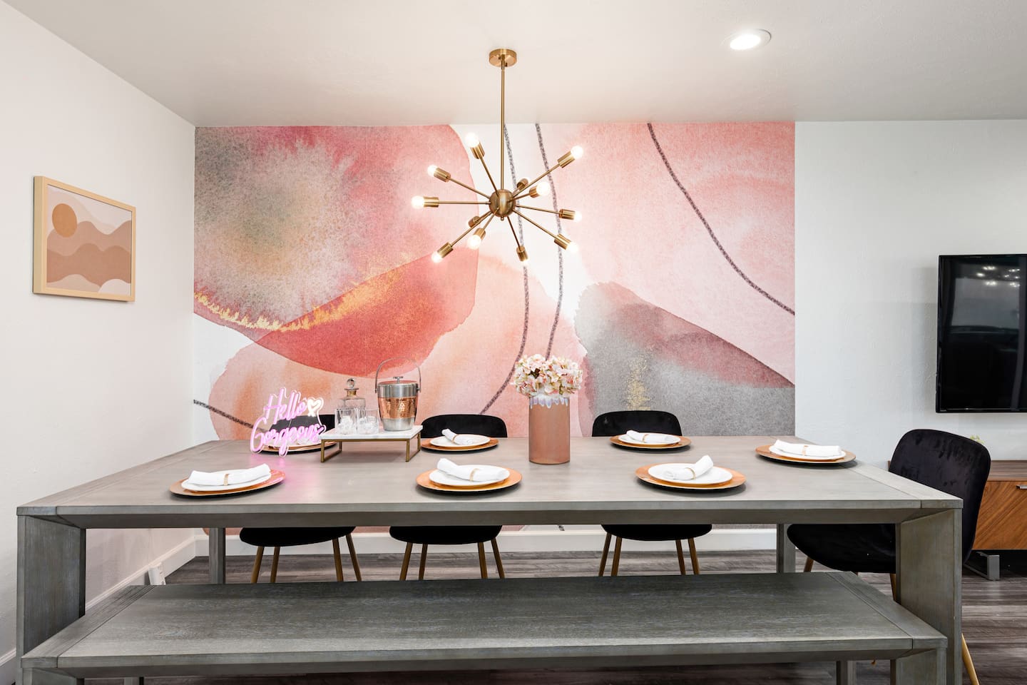 This striking dining wall features bold desert-inspired art and a contemporary chandelier for an unforgettable visual impression.

