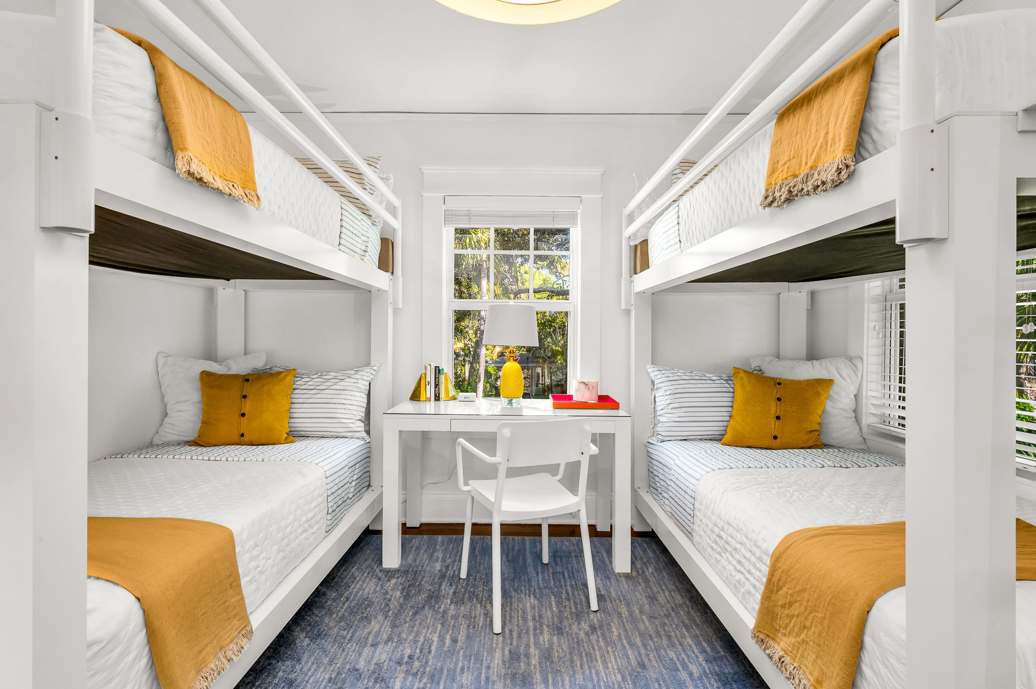 Bright and airy bunk bed bedroom featuring two new durable twin XL bunk beds, modern artwork, and a personal desk and chair—ideal for remote work. Enjoy a smart TV and peaceful views overlooking the quiet Flamingo Park street.