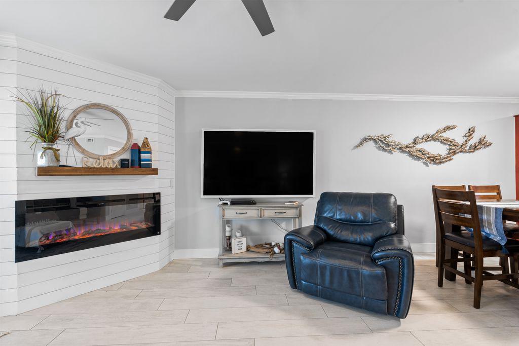 Spacious living area with recliner, fireplace, ceiling fan and smart TV