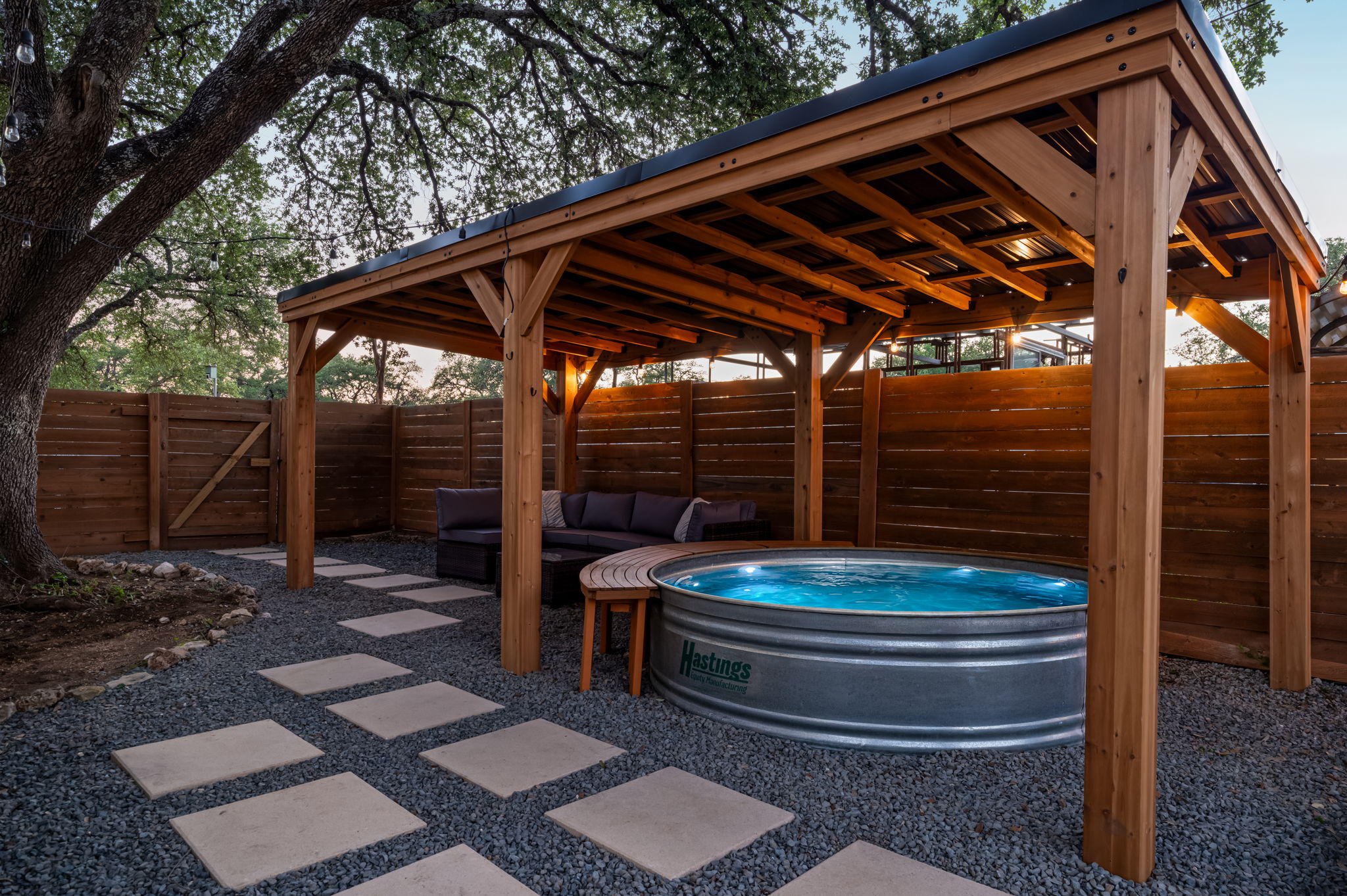 Relax in the private cowboy pool lounge featuring covered seating, cozy lighting, and a peaceful backyard setting. The perfect spot to cool off, unwind, and enjoy evenings with family and friends.