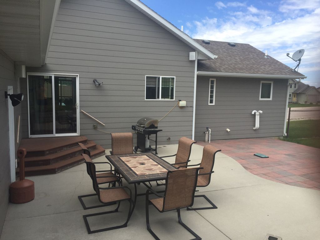Patio with grill, patio set and smoker pole.