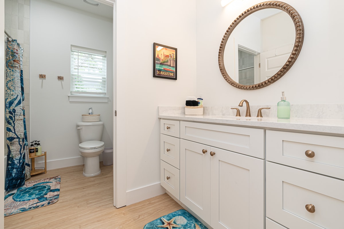 The third full bathroom sits just off the living area, with its own vanity and a St. Augustine print on the wall. With a full house, a bathroom nobody has to cross a bedroom to reach is worth a great deal.
