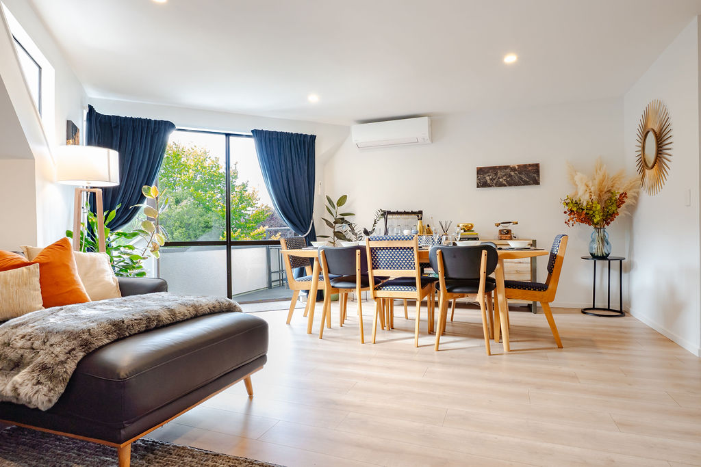 Fernhill Mountain Escape’s open-plan living and dining area brings the lounge, shared meals and balcony access together in one bright Queenstown space.