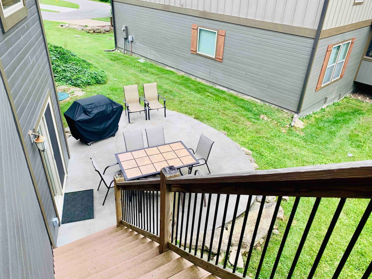 Lower level patio with propane grill, table, and seating 