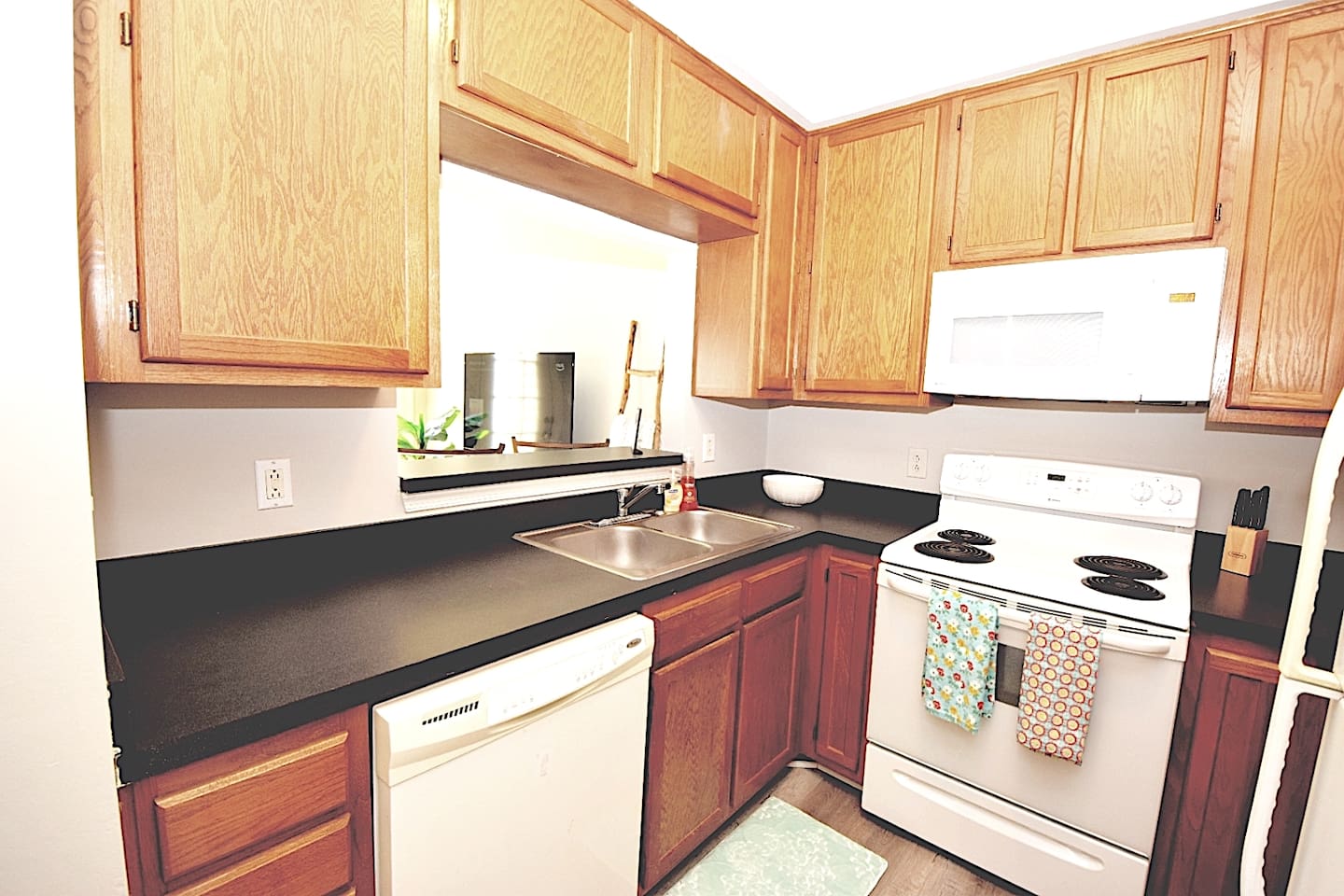 Fully equipped kitchen with all appliances including a Keurig coffee machine, coffee pods, half and half and sugar.