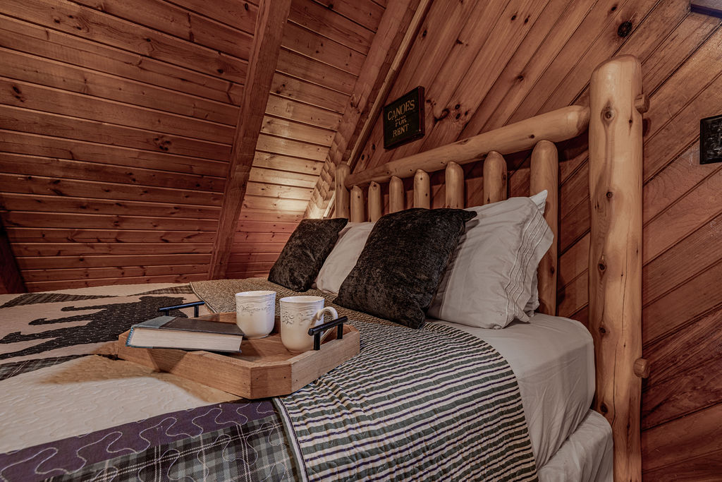 Queen bed tucked under the wooden beams